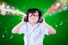 smiling-boy-listening-music-while-standing-against-green-background_1048944-22175873.jpg